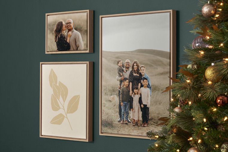 framed canvas prints hanging on a wall next to a christmas tree